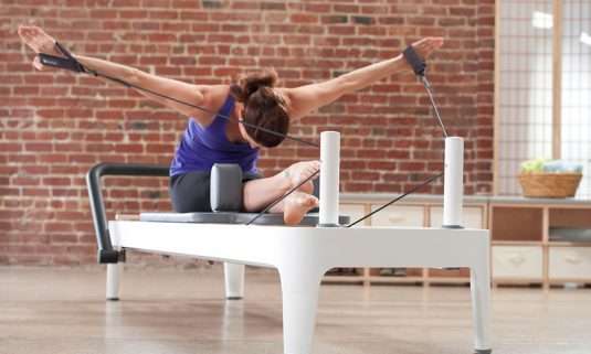 A lady performing pilates reformer in axiongym.gr